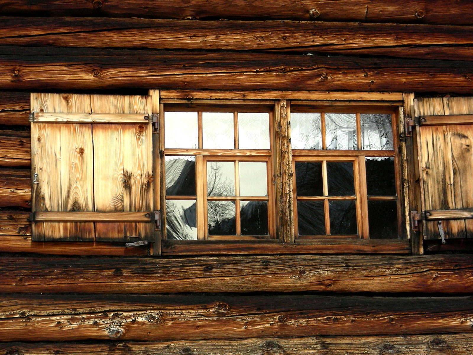 Sprossenfenster aus Holz in einer alten Blockhausfassade