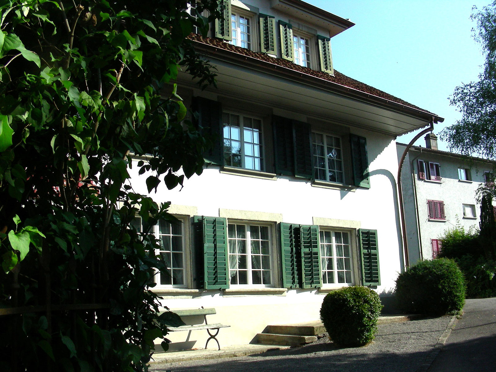 Herrschaftshaus mit grünen Fensterläden und Fenstertüren
